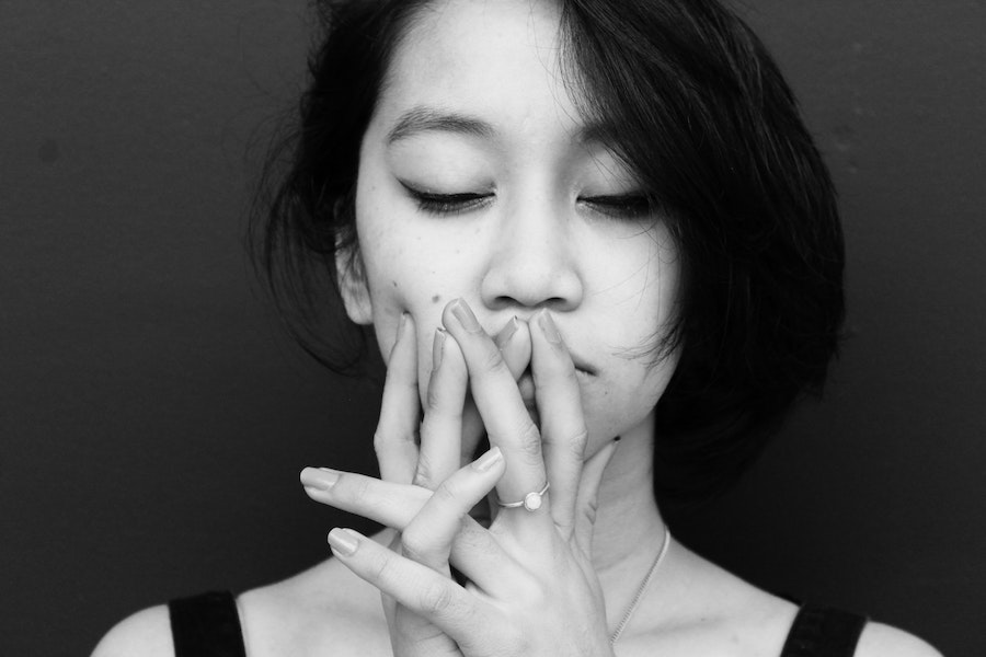 Woman holding hands over her mouth